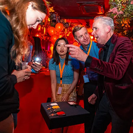 Gasten kiezen geconcentreerd een sleutel tijdens een interactieve act van goochelaar Jan Smulders bij Holy Moly Breda, met de kans op het winnen van 100 euro.