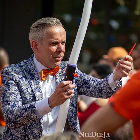 Goochelaar Jan Smulders duwt een scherpe pen door een ballon zonder dat deze knapt tijdens Koningsdag in Rijsbergen.