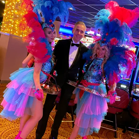 Goochelaar Jan Smulders in smoking samen met de Candy Girls tijdens de kerstshow Christmas Magic in Holland Casino.