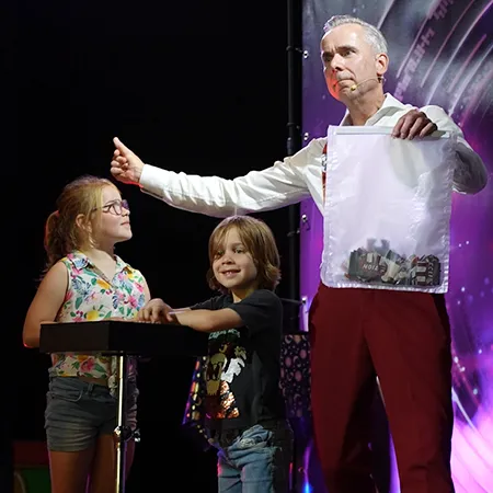 Kinderen helpen Goochelaar Jan Smulders op het podium tijdens een interactieve goochelshow bij Molecaten.